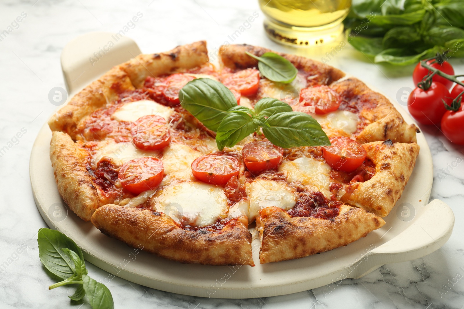 Photo of Delicious Margherita pizza and ingredients on white marble table