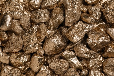 Photo of Many gold nuggets as background, top view