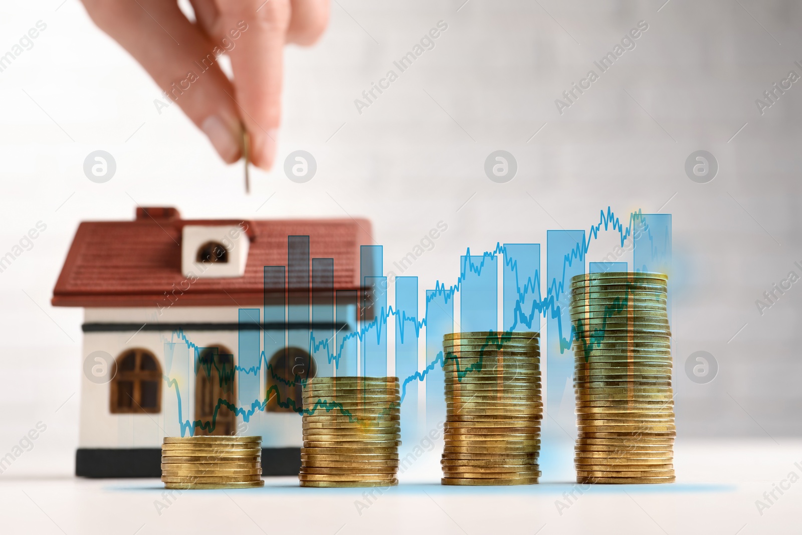 Image of Mortgage rate. Stacked coins and graphs. Woman putting coin into house shaped money box, closeup.