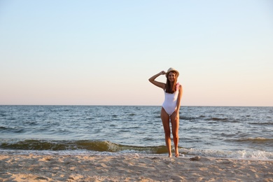 Photo of Beautiful young woman on sandy beach near sea
