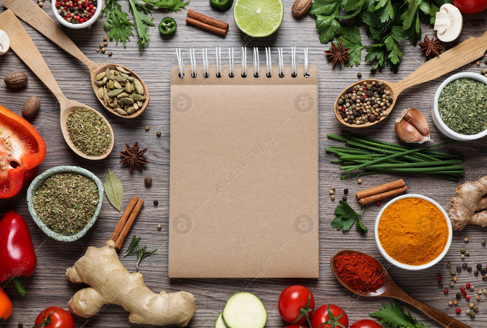 Photo of Open recipe book and different ingredients on wooden table, flat lay. Space for text