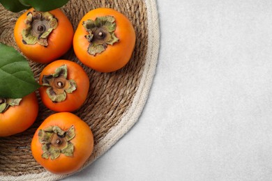 Photo of Delicious ripe juicy persimmons on light table, flat lay. Space for text