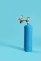 Oxygen tank on light blue background. Medical equipment