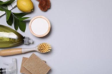 Photo of Flat lay composition with different cleaning supplies on light gray background, space for text