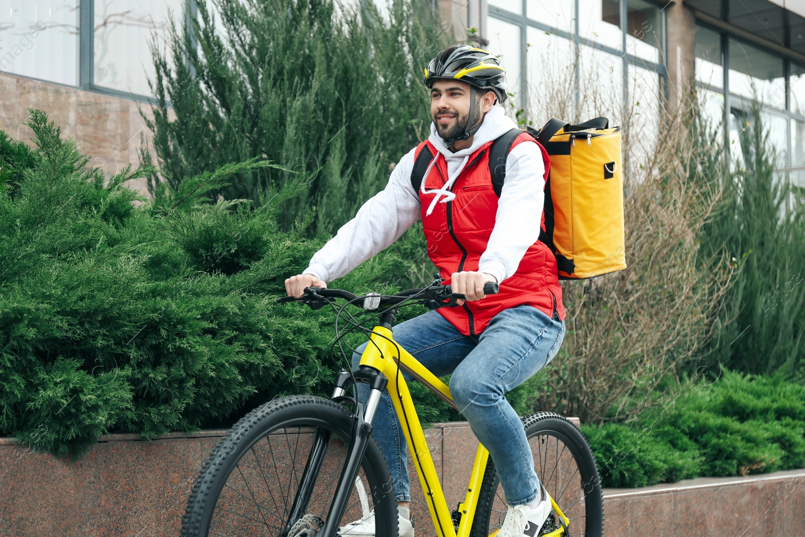 Photo of Courier with thermo bag riding bicycle outdoors. Food delivery service