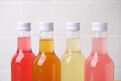 Photo of Delicious kombucha in glass bottles against light background