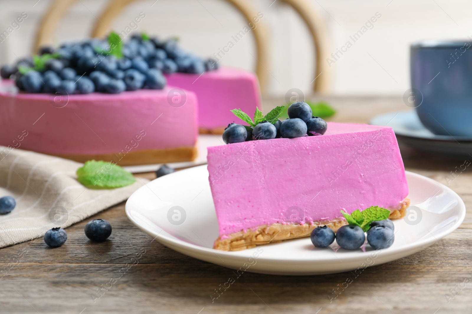 Photo of Plate with piece of tasty blueberry cake on wooden table