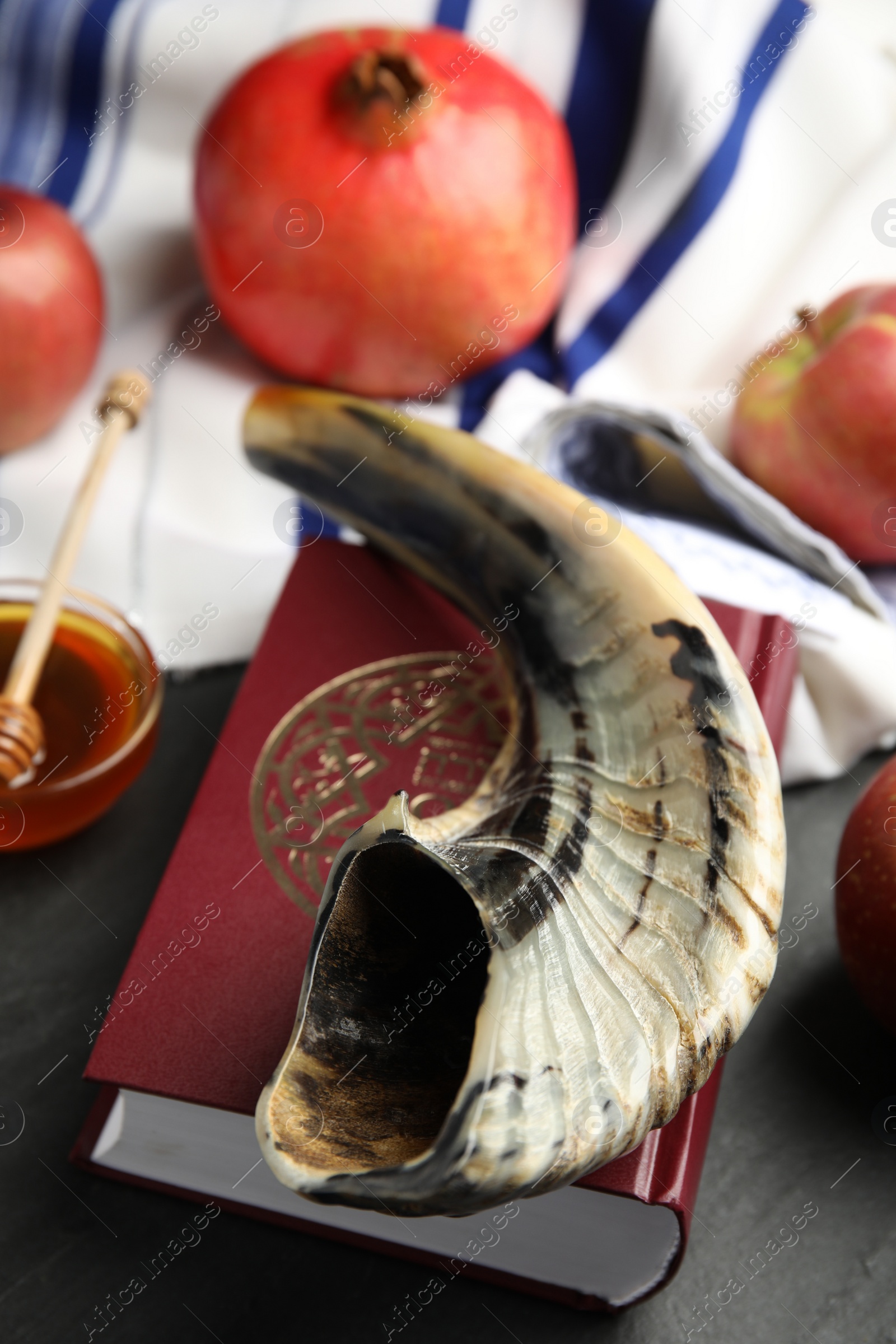 Photo of Shofar and Torah on black table, closeup. Rosh Hashanah celebration