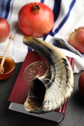 Shofar and Torah on black table, closeup. Rosh Hashanah celebration