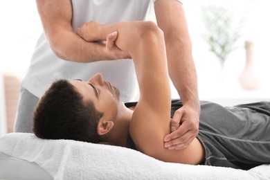 Young man receiving massage in salon, closeup