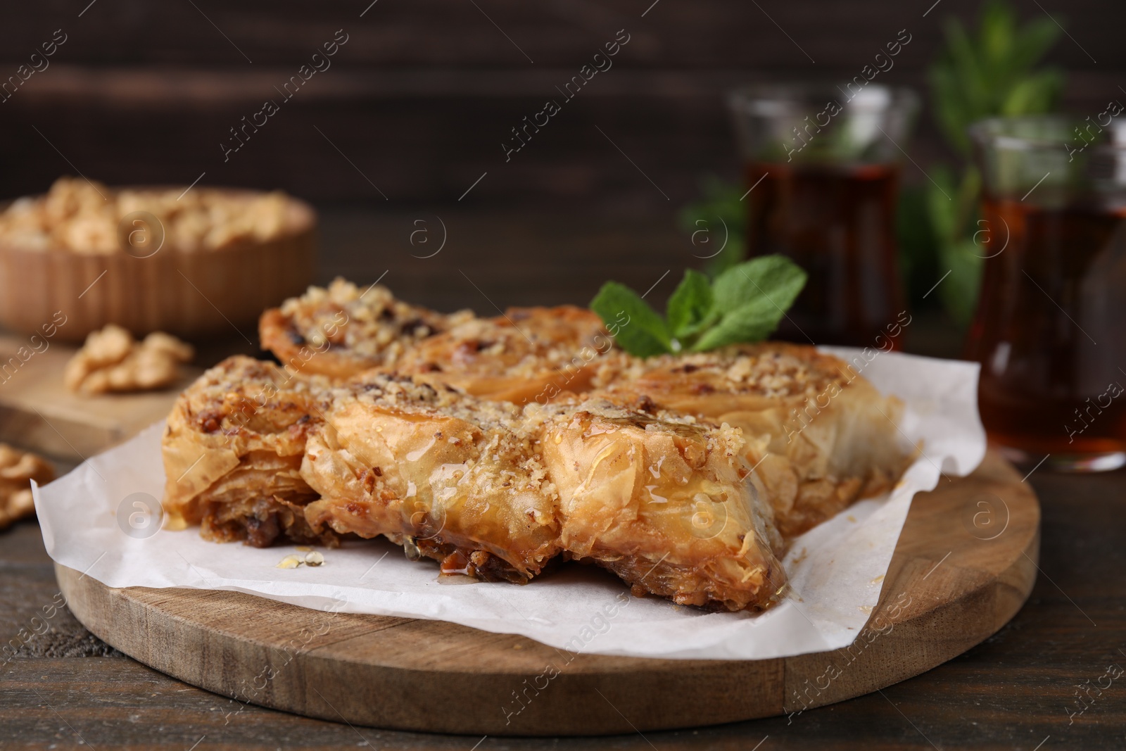 Photo of Eastern sweets. Pieces of tasty baklava on wooden table, closeup