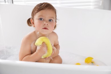 Photo of Cute little girl with bast wisp taking bubble bath. Space for text