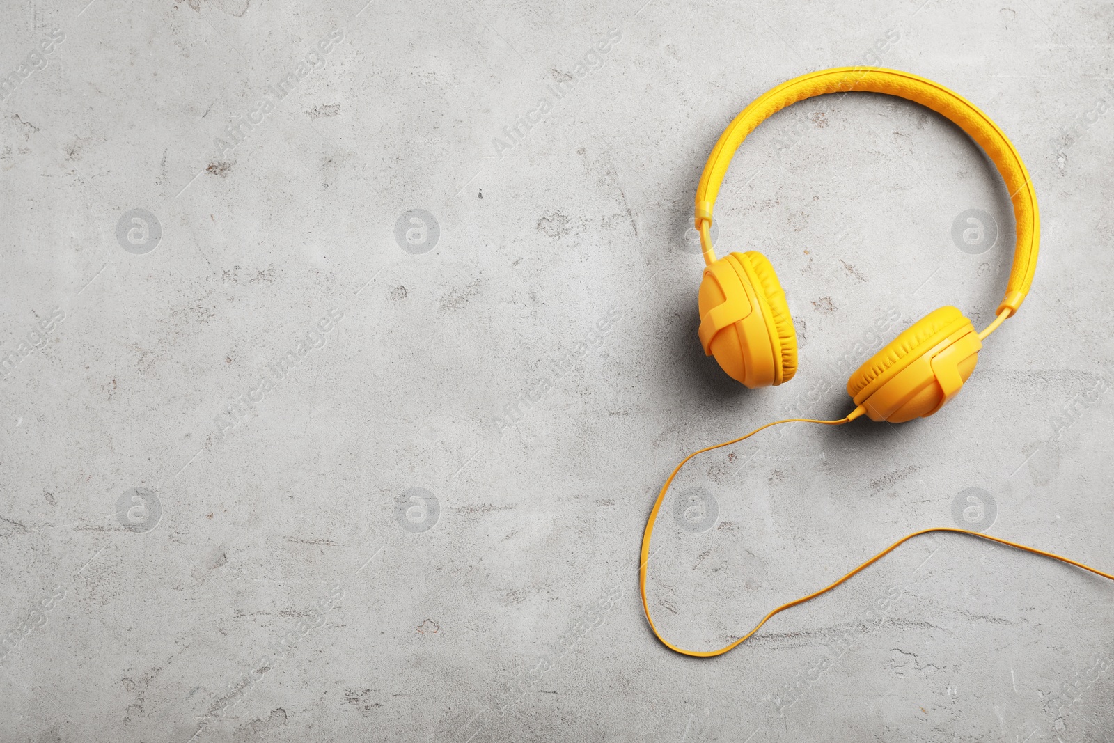 Photo of Stylish modern headphones and space for text on gray background, top view