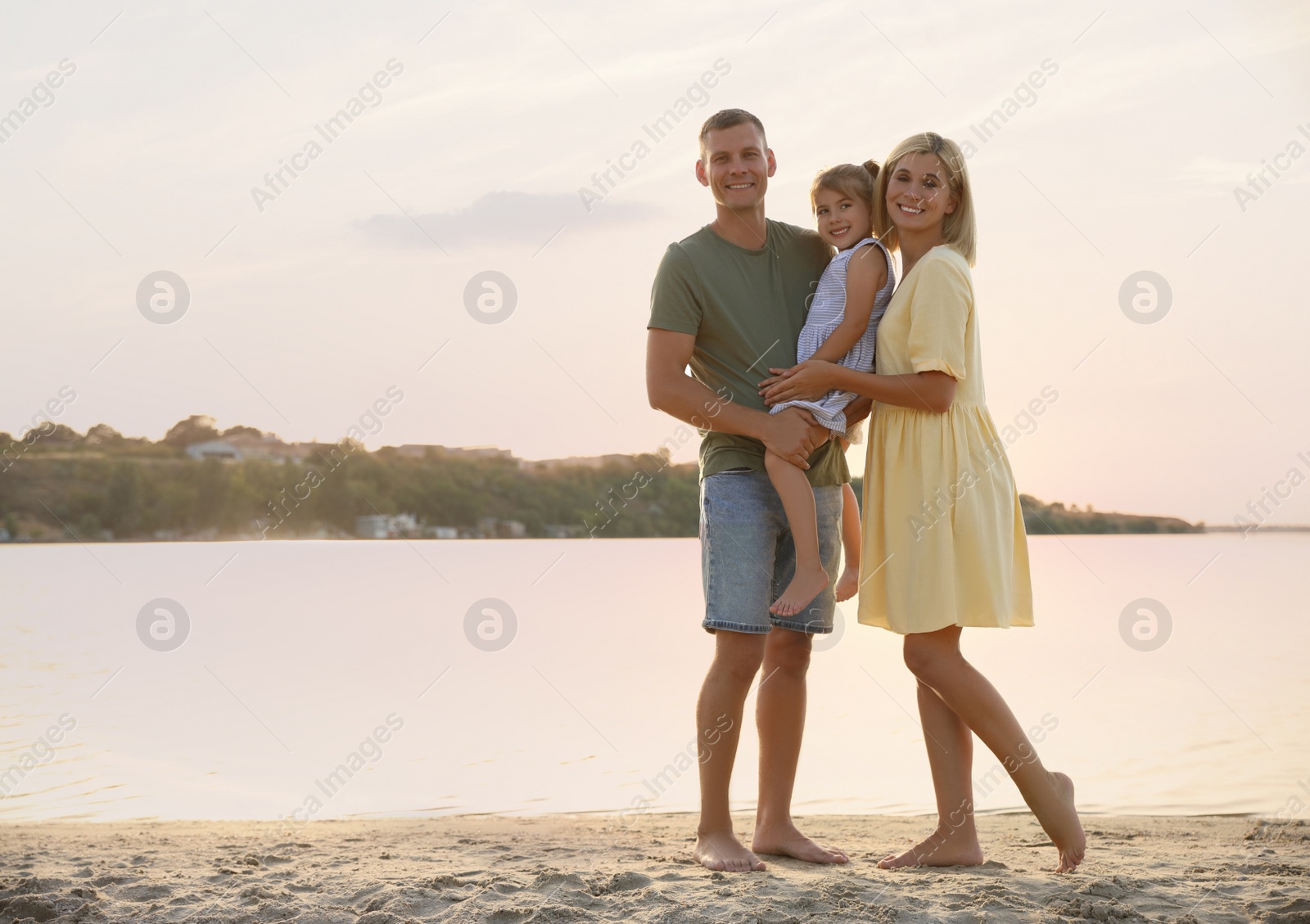 Photo of Happy parents with their child on beach, space for text. Spending time in nature