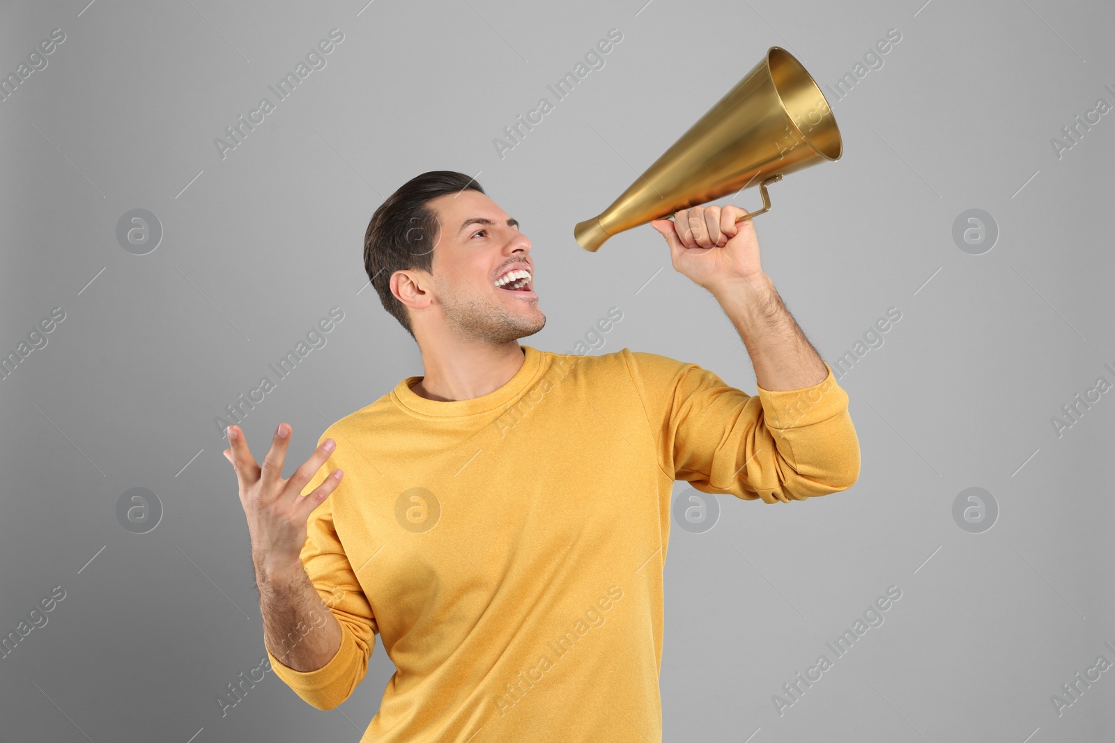 Photo of Handsome man with megaphone on grey background