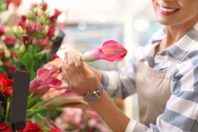 Photo of Female florist working in flower shop, closeup