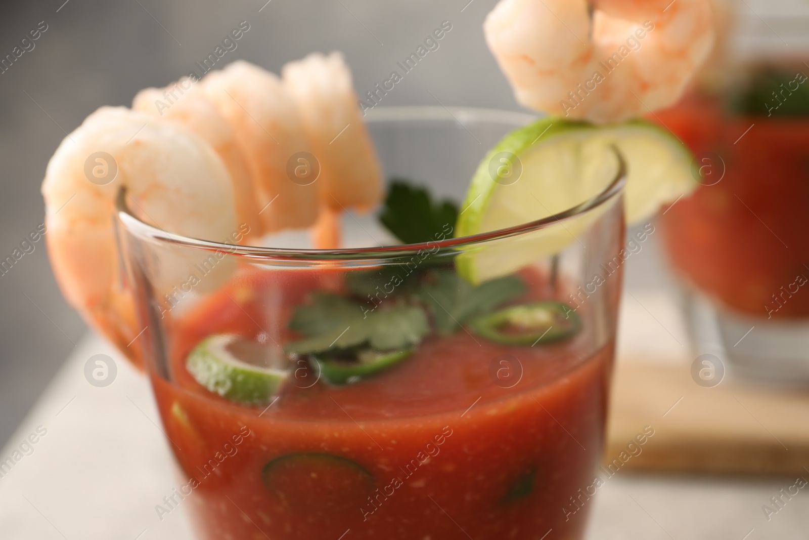 Photo of Tasty shrimp cocktail with sauce in glass and lime on table, closeup