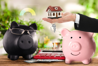 Image of Piggy banks, money and calculator on table. Saving money for house purchase 