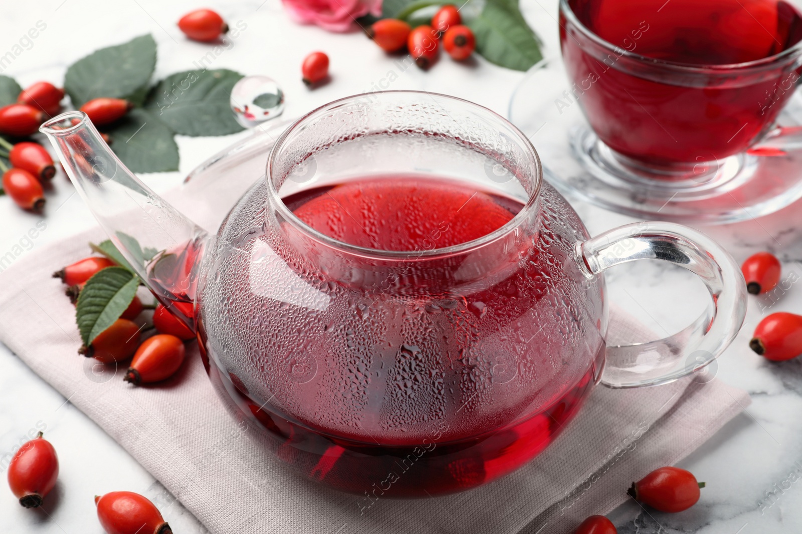 Photo of Fresh rose hip tea and berries on white marble table