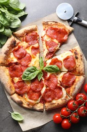 Photo of Tasty pepperoni pizza, cutter and ingredients on grey table, flat lay