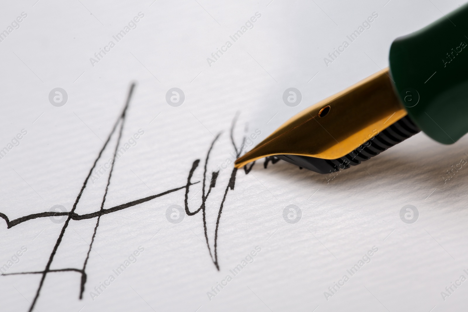 Photo of Signing on sheet of paper with fountain pen, closeup