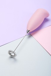 Photo of Pink milk frother wand on color background