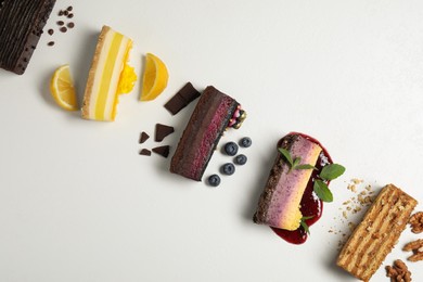 Photo of Flat lay composition with different tasty cakes on light table