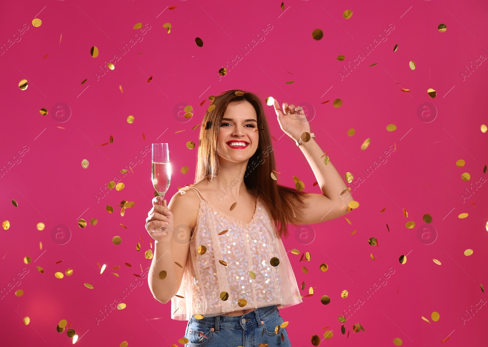 Photo of Portrait of happy woman with champagne in glass and confetti on color background