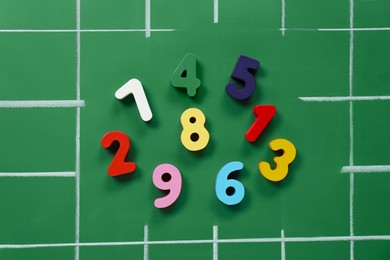 Photo of Many colorful numbers on green chalkboard, flat lay