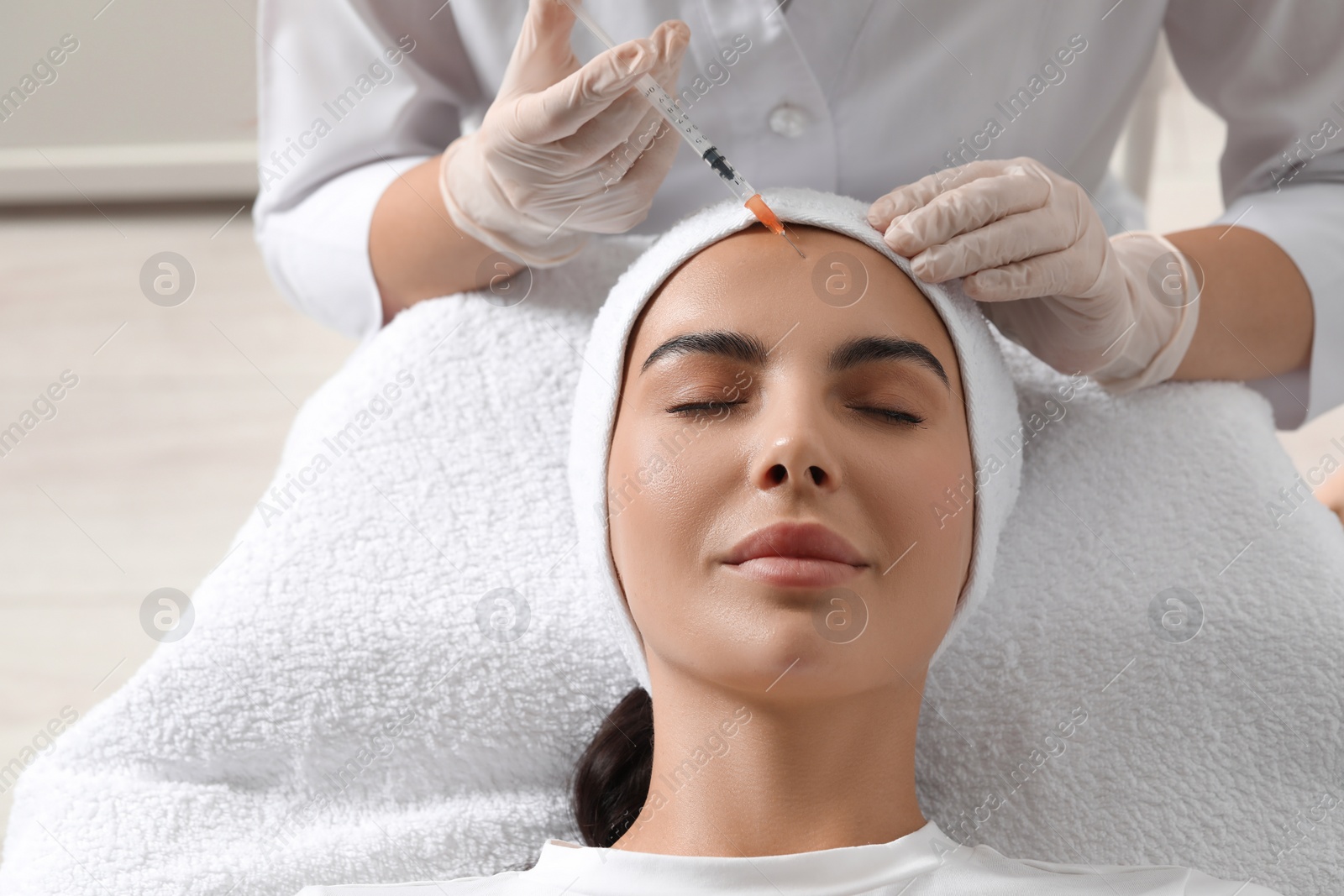 Photo of Doctor giving facial injection to young woman in clinic. Cosmetic surgery