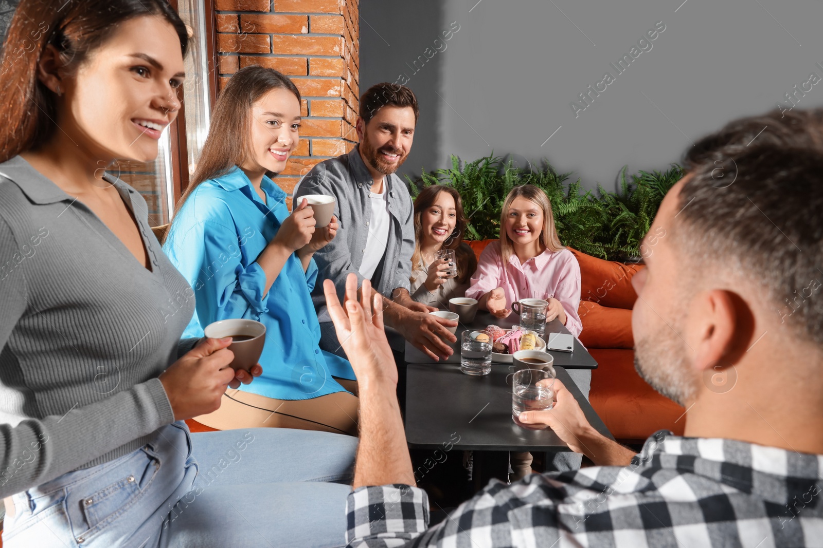 Photo of Friends with coffee spending time together in cafe