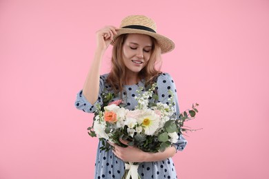 Photo of Beautiful woman in straw hat with bouquet of flowers on pink background