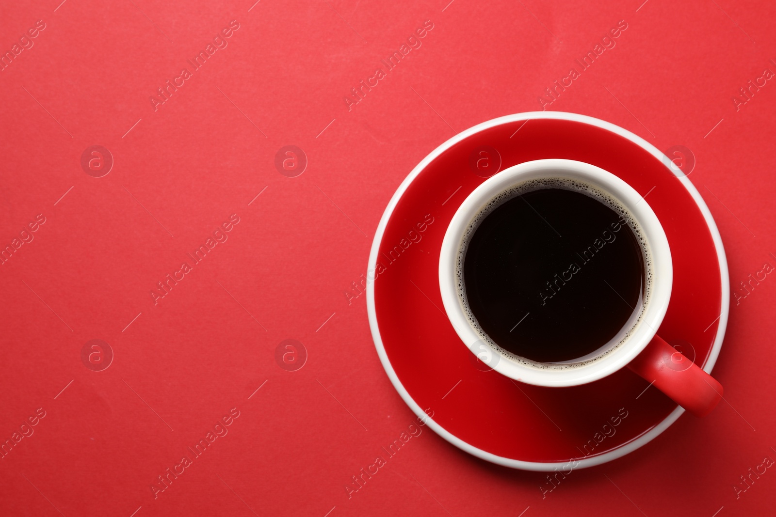 Photo of Aromatic coffee in cup on red background, top view. Space for text