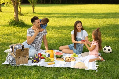 Photo of Happy family having picnic in park on sunny summer day