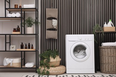 Photo of Laundry room interior with washing machine and stylish furniture