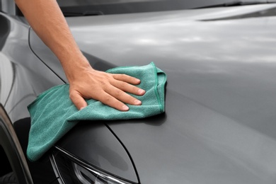 Man washing car hood with rag, closeup