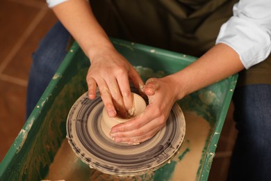 Clay crafting. Woman making bowl on potter's wheel, closeup