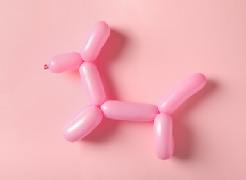 Photo of Dog figure made of modelling balloon on pink background, top view