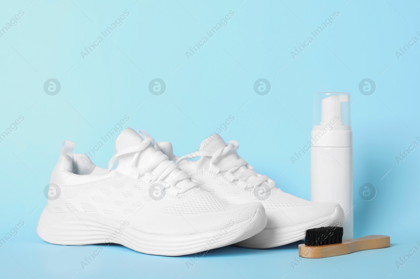 Photo of Stylish footwear and shoe care accessories on light blue background