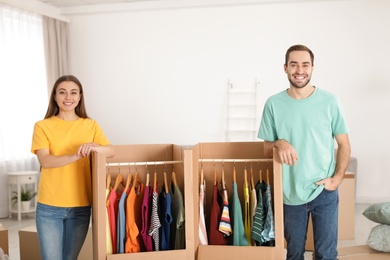 Young couple near wardrobe boxes at home