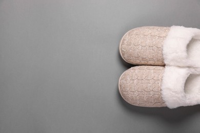 Photo of Pair of beautiful soft slippers on grey background, top view. Space for text