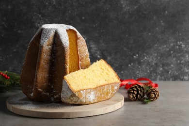 Photo of Delicious Pandoro cake with powdered sugar and Christmas decor on grey table. Space for text