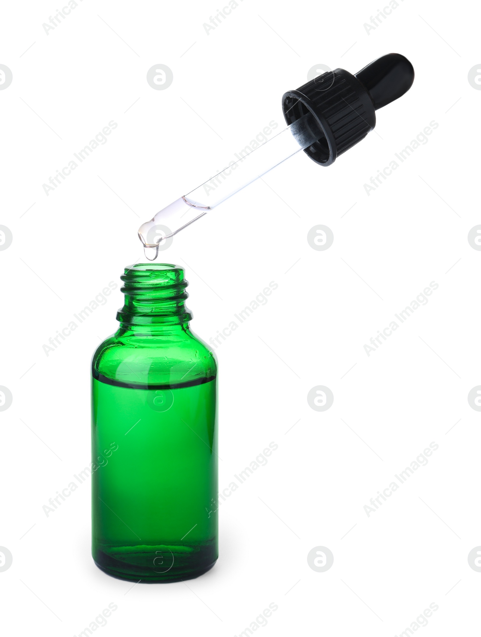 Photo of Dripping essential oil from pipette into bottle isolated on white