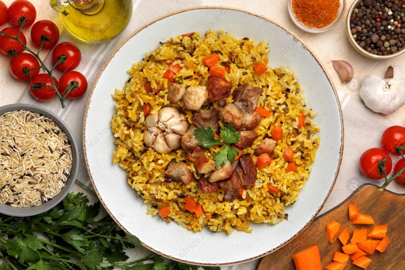 Photo of Delicious pilaf and products on table, flat lay