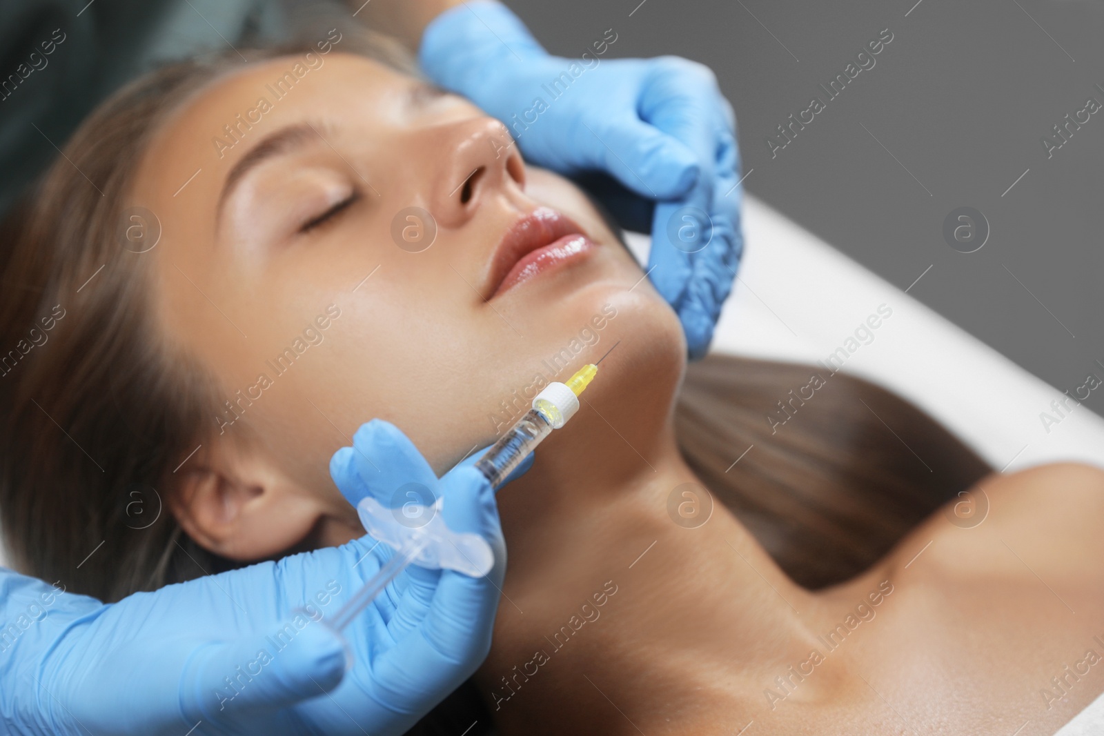 Photo of Beautiful woman getting facial injection in salon