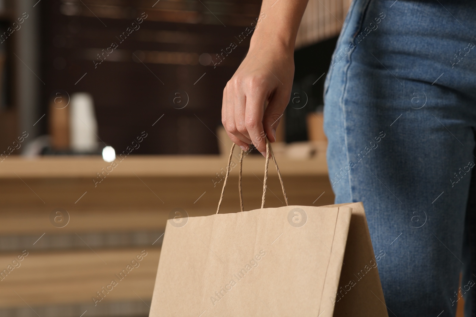 Photo of Woman with paper bag in cafe, closeup. Space for text