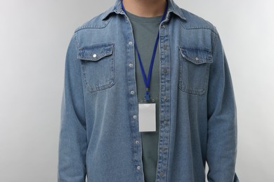 Man with blank badge on grey background, closeup