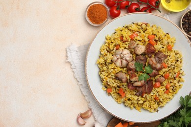 Delicious pilaf and products on beige table, flat lay. Space for text