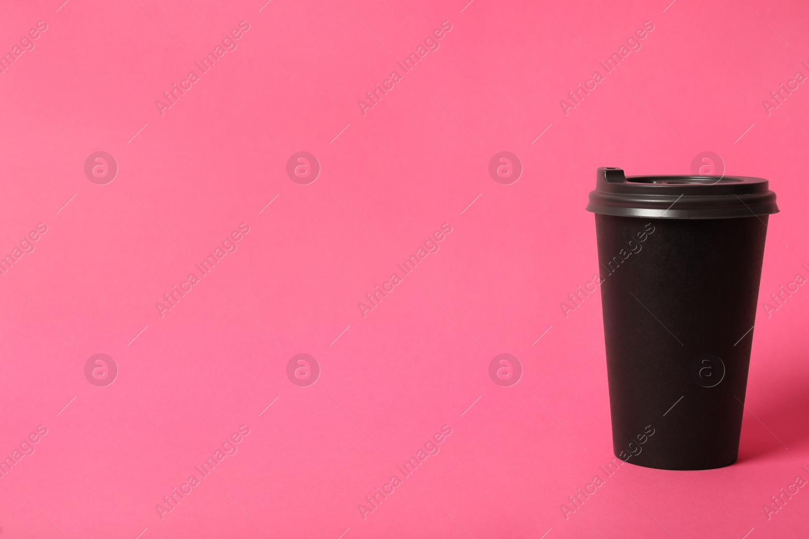 Photo of Takeaway paper coffee cup on pink background. Space for text