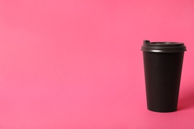 Takeaway paper coffee cup on pink background. Space for text